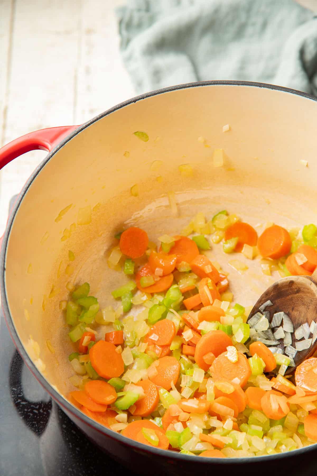 Carrots, celery, and onions cooking in a pot.