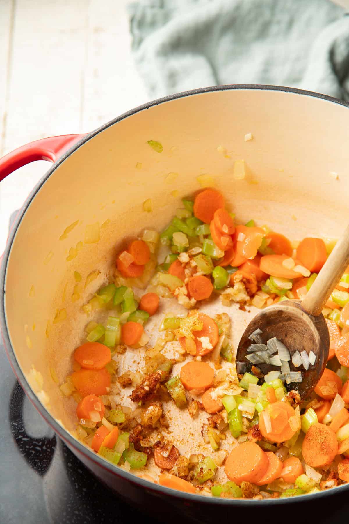 Carrots, celery, onion, garlic, and spices cooking in a pot.