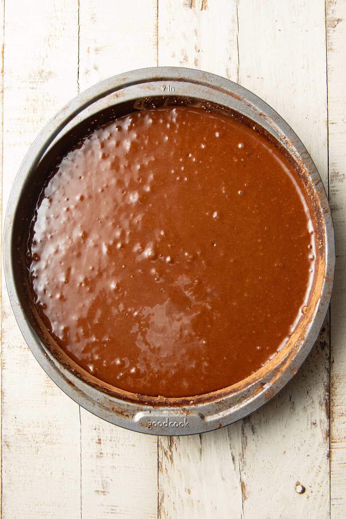 Chocolate cake batter in a round pan.