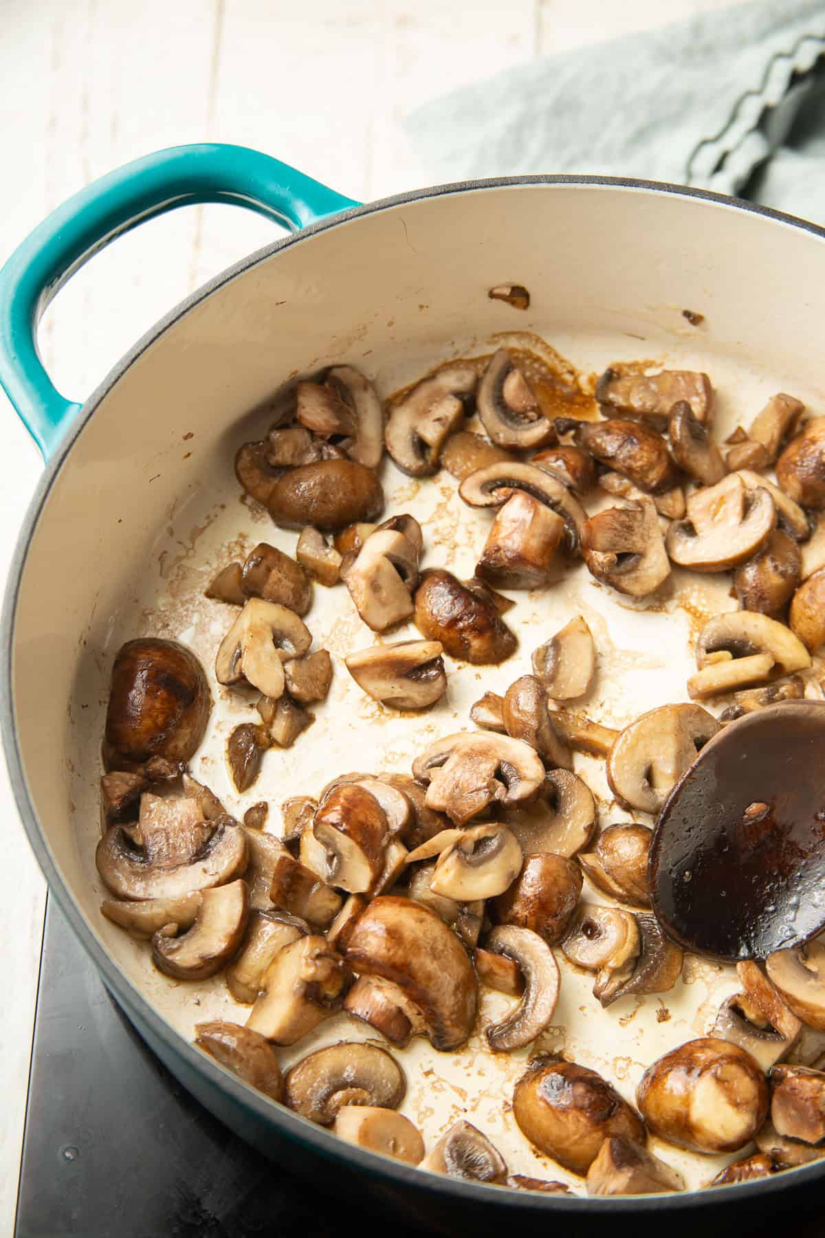 Sliced mushrooms cooking in olive oil.