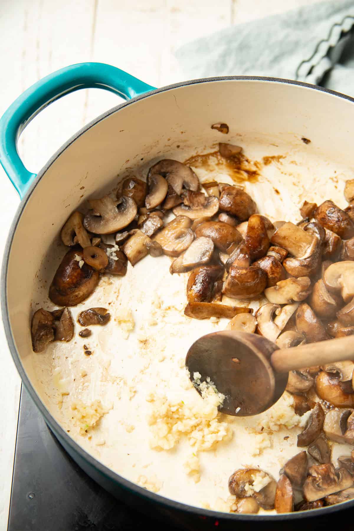 Minced garlic cooking in a dish with mushrooms.