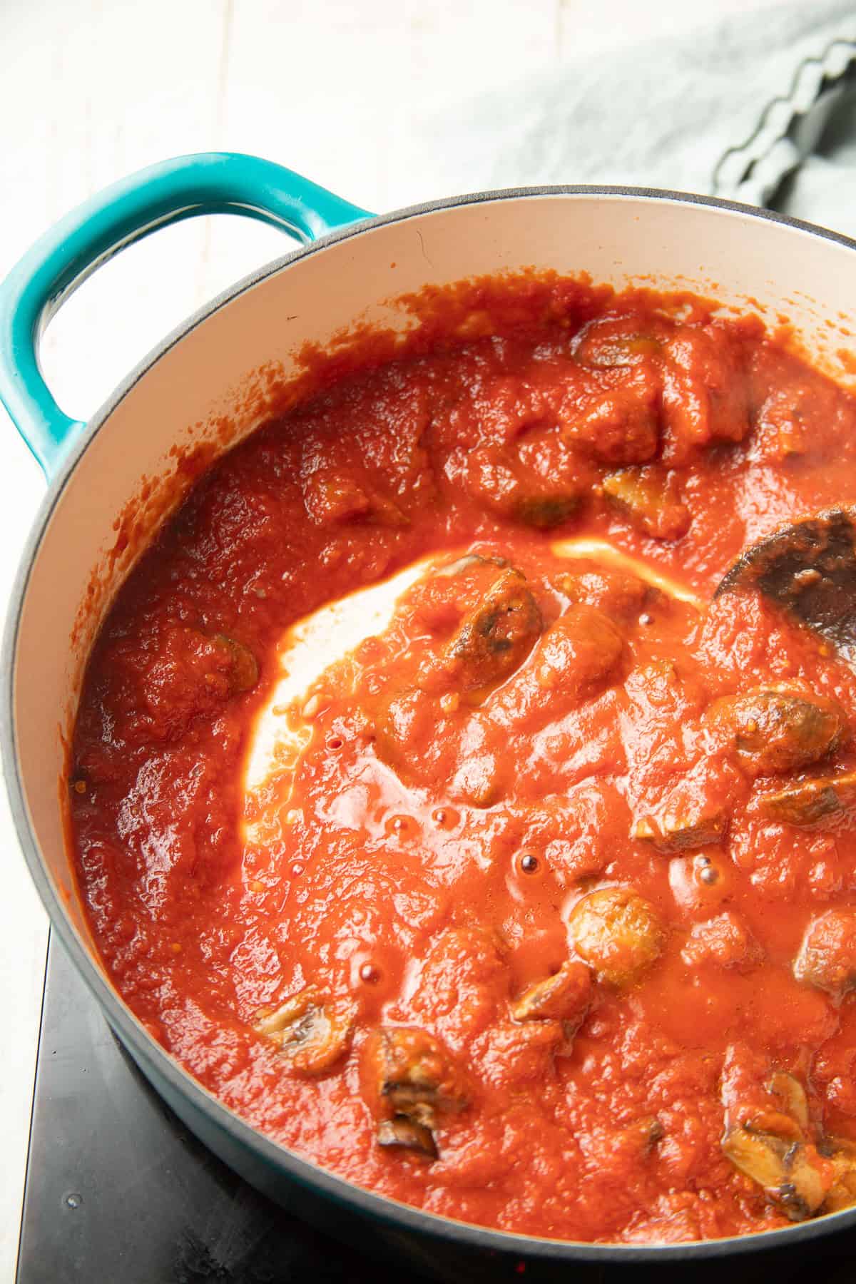 Mushrooms simmering in tomato sauce.