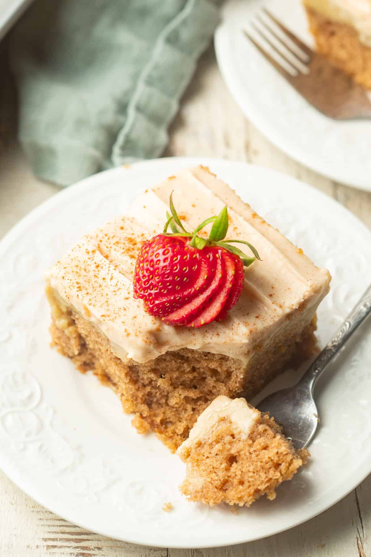 Slice of vegan poke cake on a dish with a bite resting on a fork.
