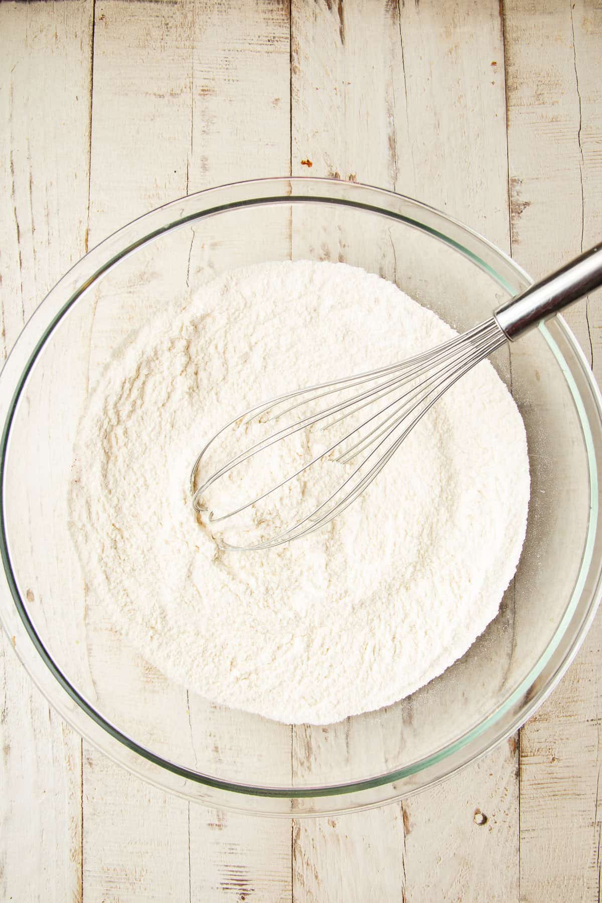 Dry ingredients for Vegan Strawberry Roll in a mixing bowl with wire whisk.