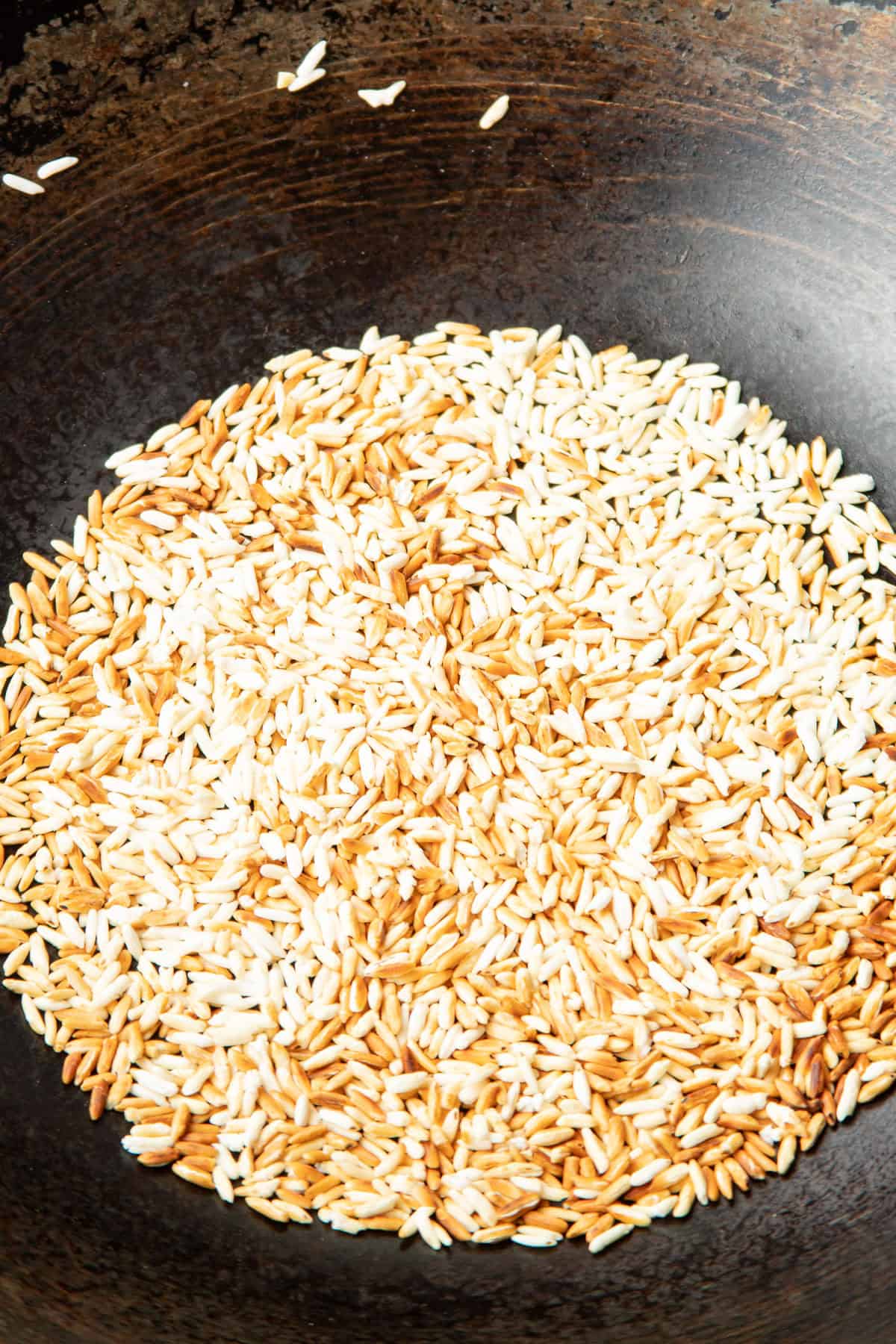 Toasted jasmine rice in a wok.