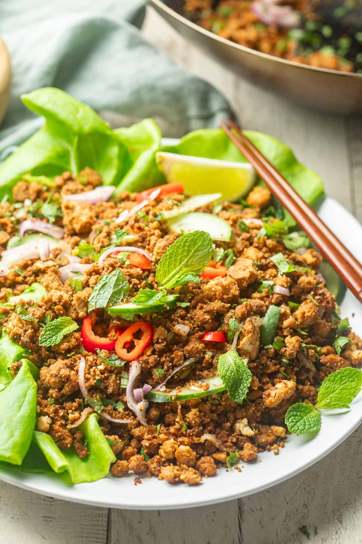 Plate of Vegan Larb with a wok in the background.