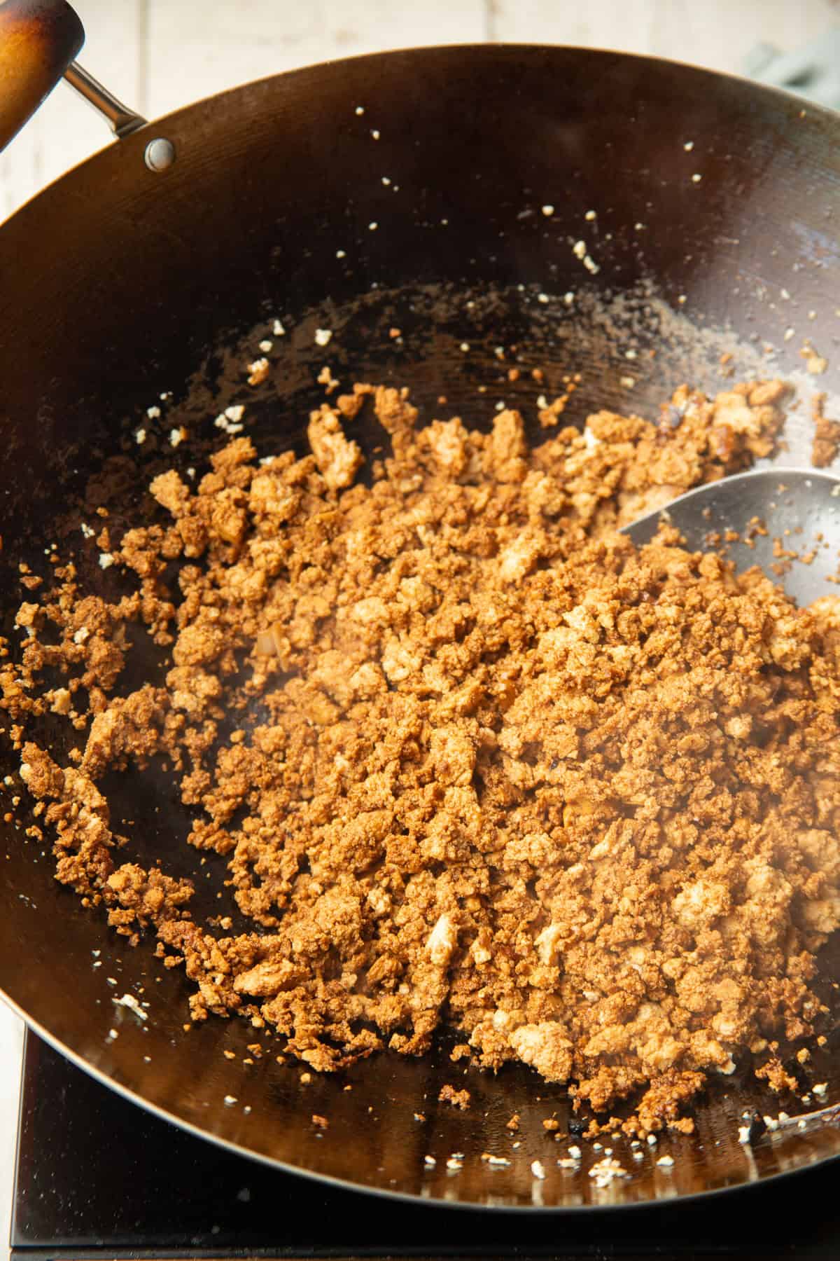 Seasoned crumbled tofu cooking in a wok.