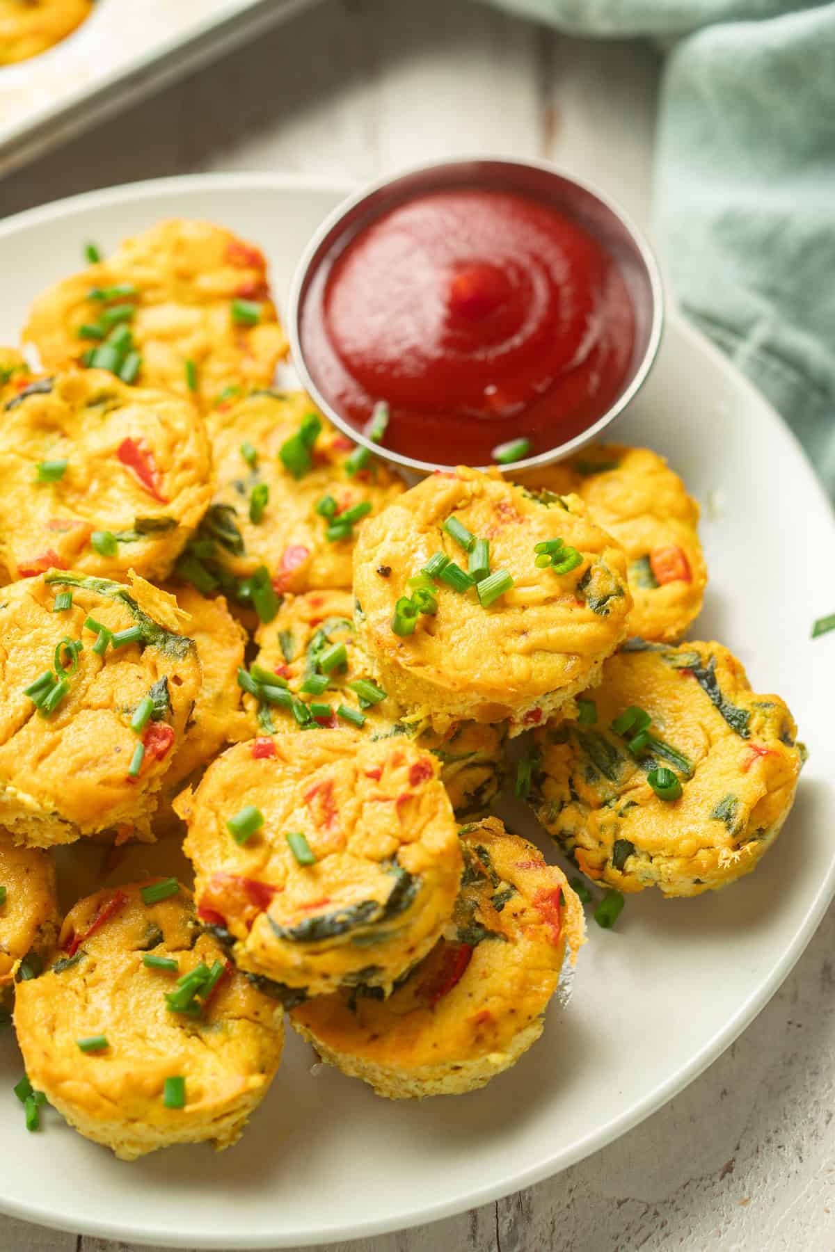 Plate of Vegan Egg Bites with napkin and muffin tin in the background.