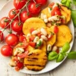 Plate of grilled polenta, white bean bruschetta, and cherry tomatoes.