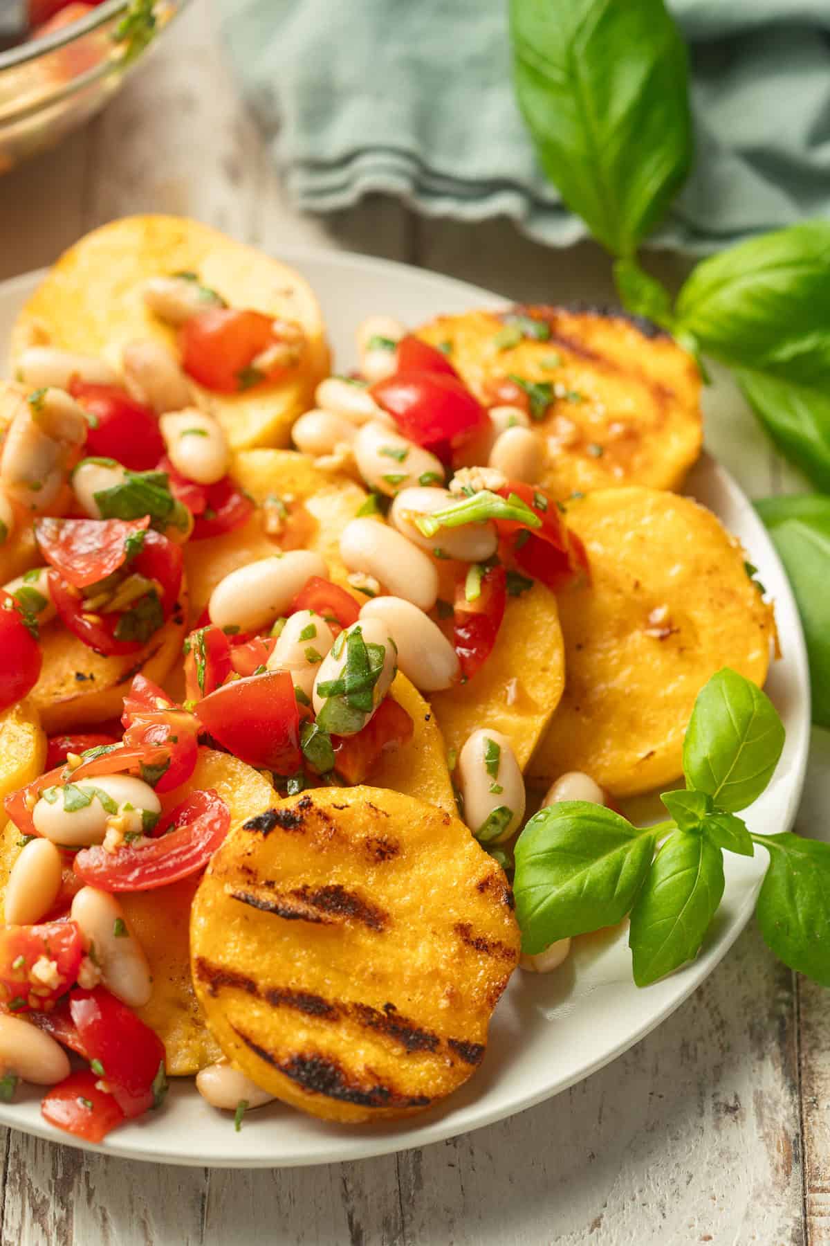 Plate of Grilled Polenta topped with white bean bruschetta.