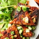 Grilled Tempeh triangles topped with diced cucumber, avocado, and peanuts.