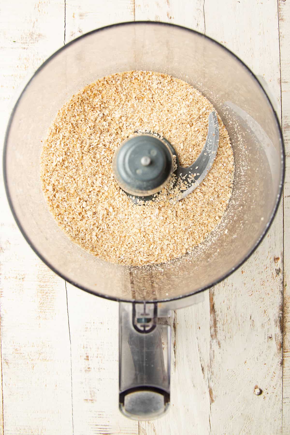 Ground walnuts in a food processor bowl.