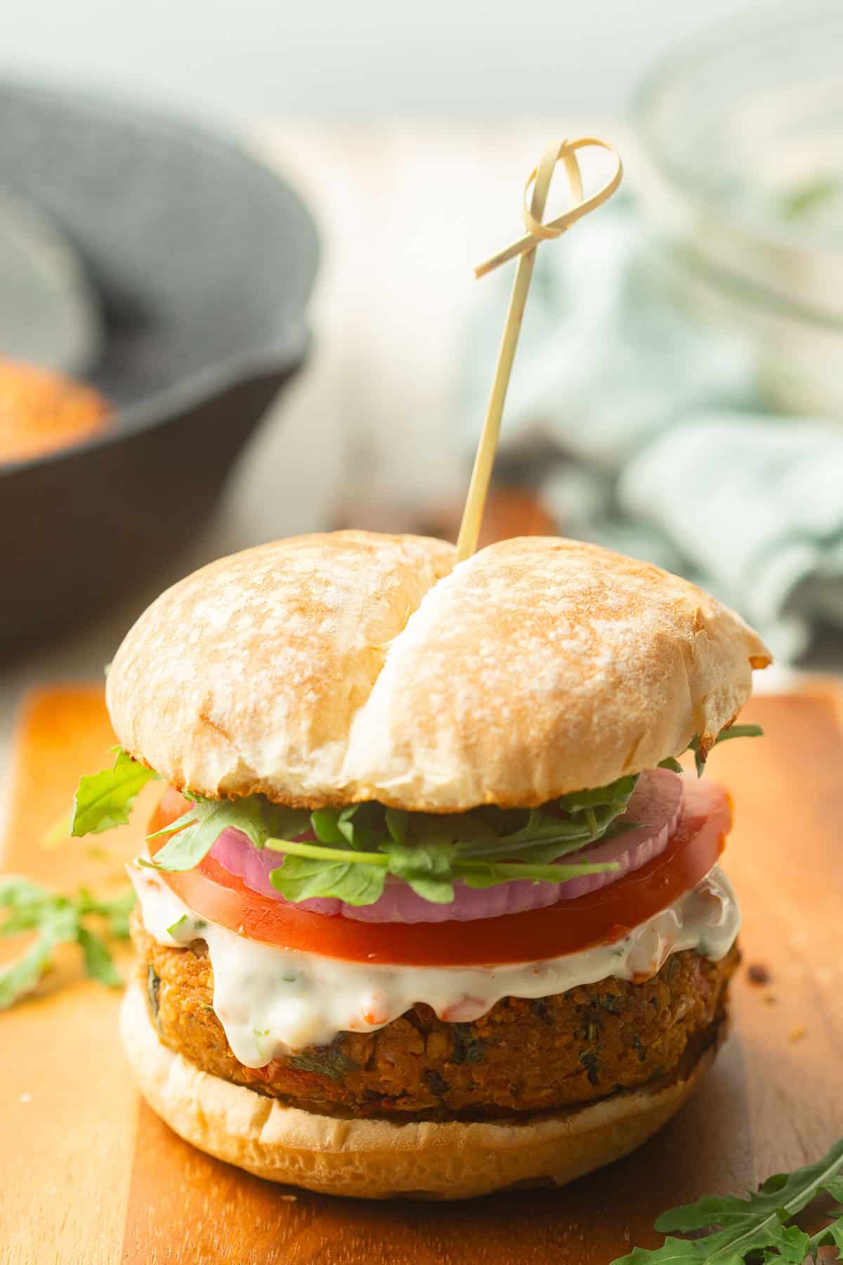 Marry Me Chickpea Burger with a skillet and bowl in the background.
