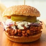 Shredded Tofu Barbecue Sandwich topped with coleslaw and pickle slices.