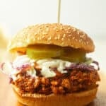 Shredded Tofu Barbecue Sandwich topped with coleslaw and pickle slices.