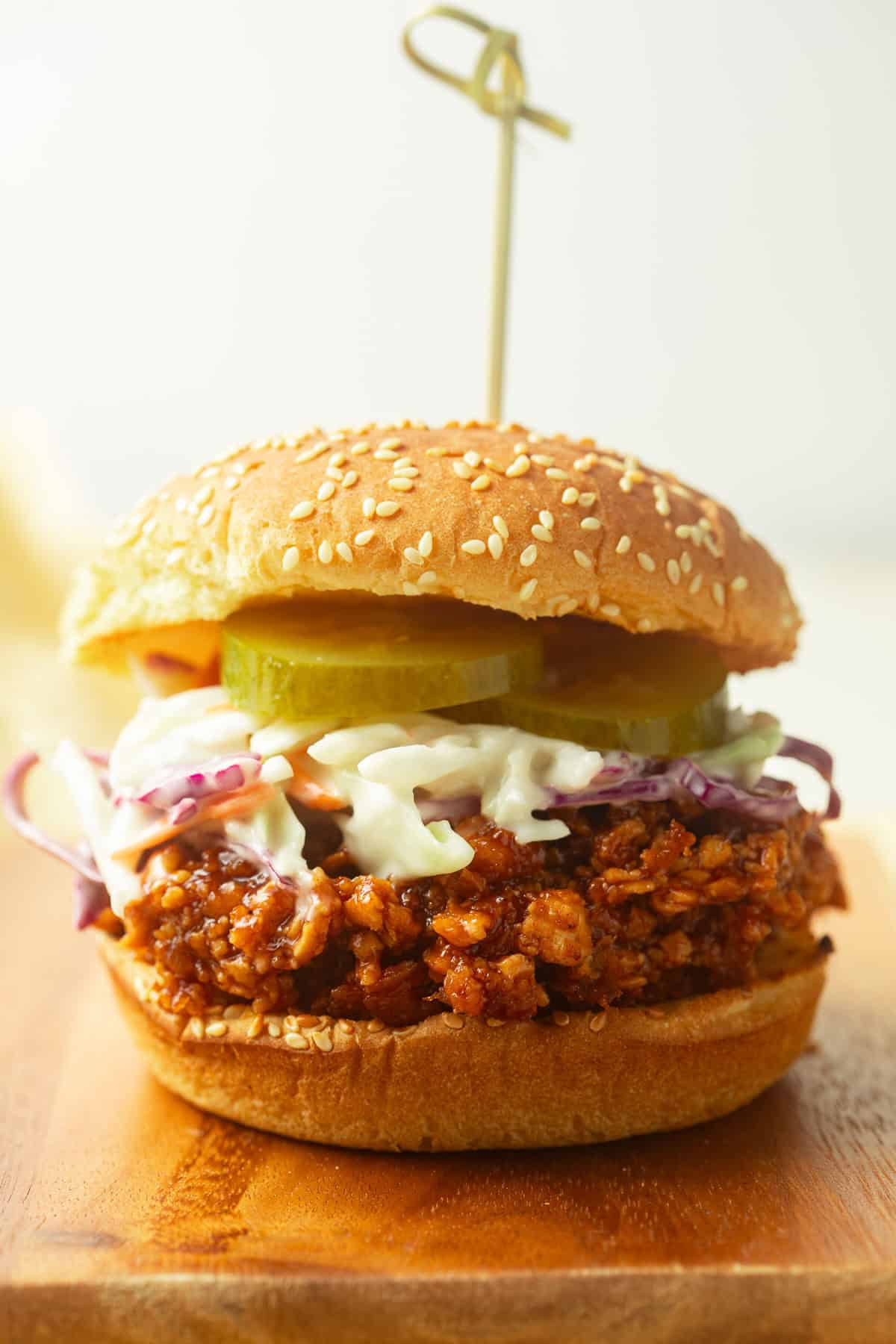 Shredded Tofu Barbecue Sandwich topped with coleslaw and pickle slices.