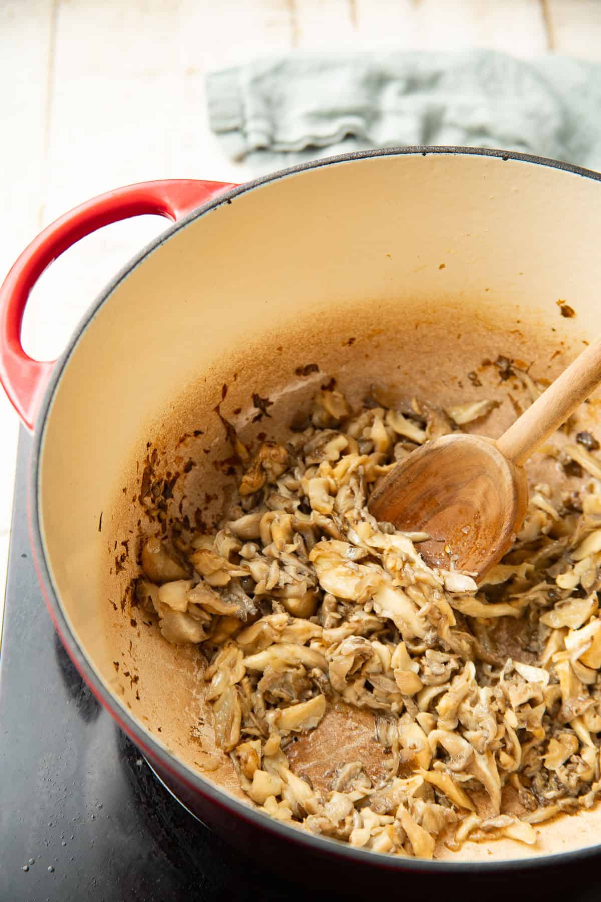 Shredded mushrooms cooking in a pot.