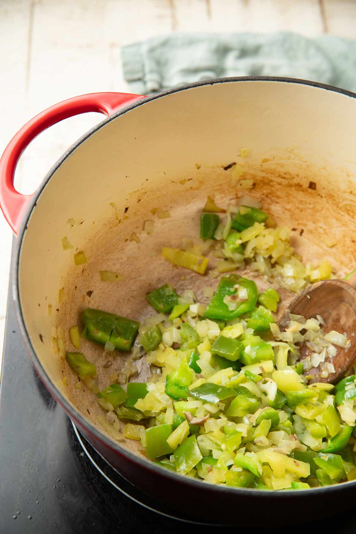 Diced peppers and onions cooking in a pot.