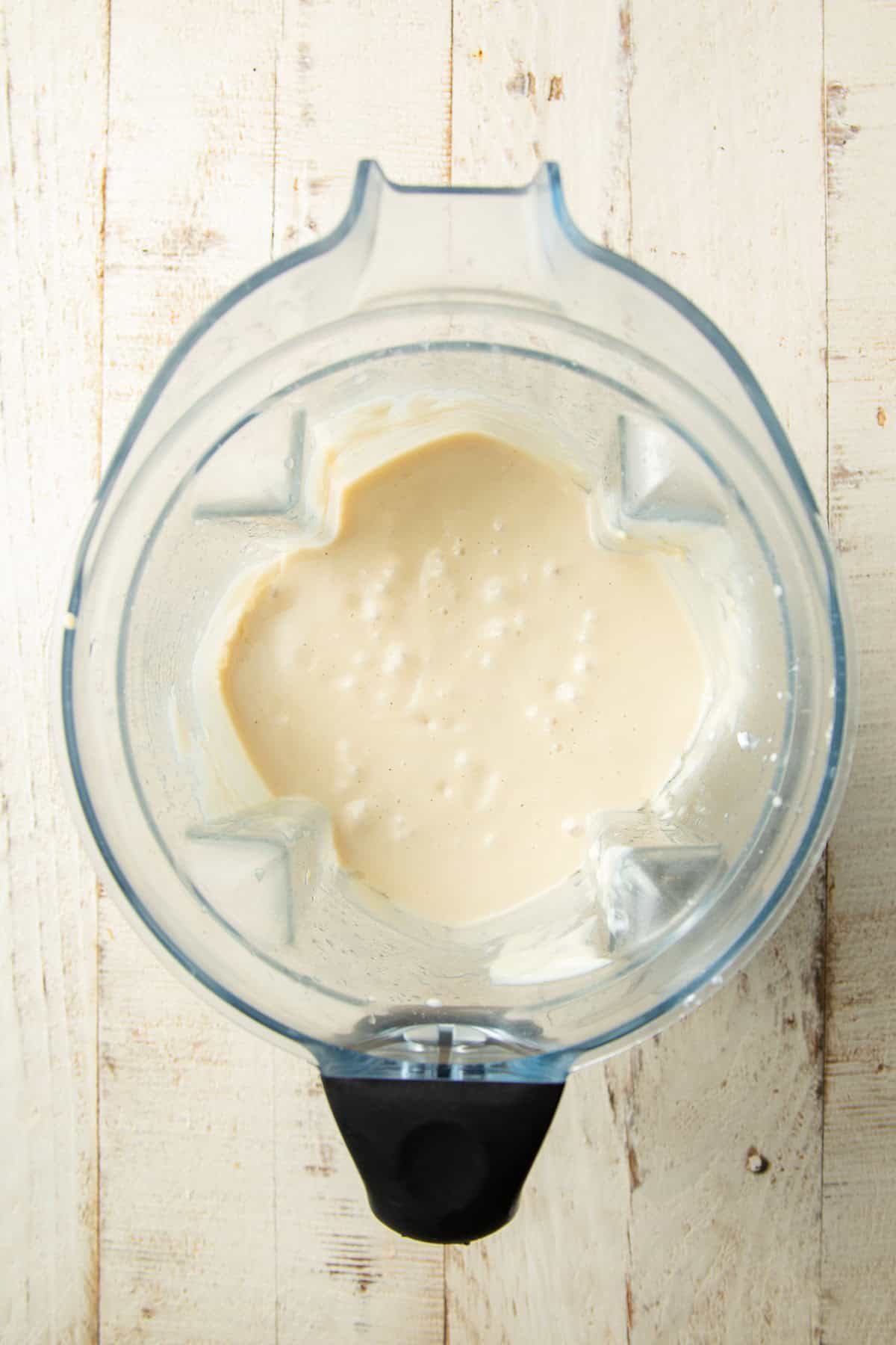 Blended cashew cream and coconut cream mixture in a blender.