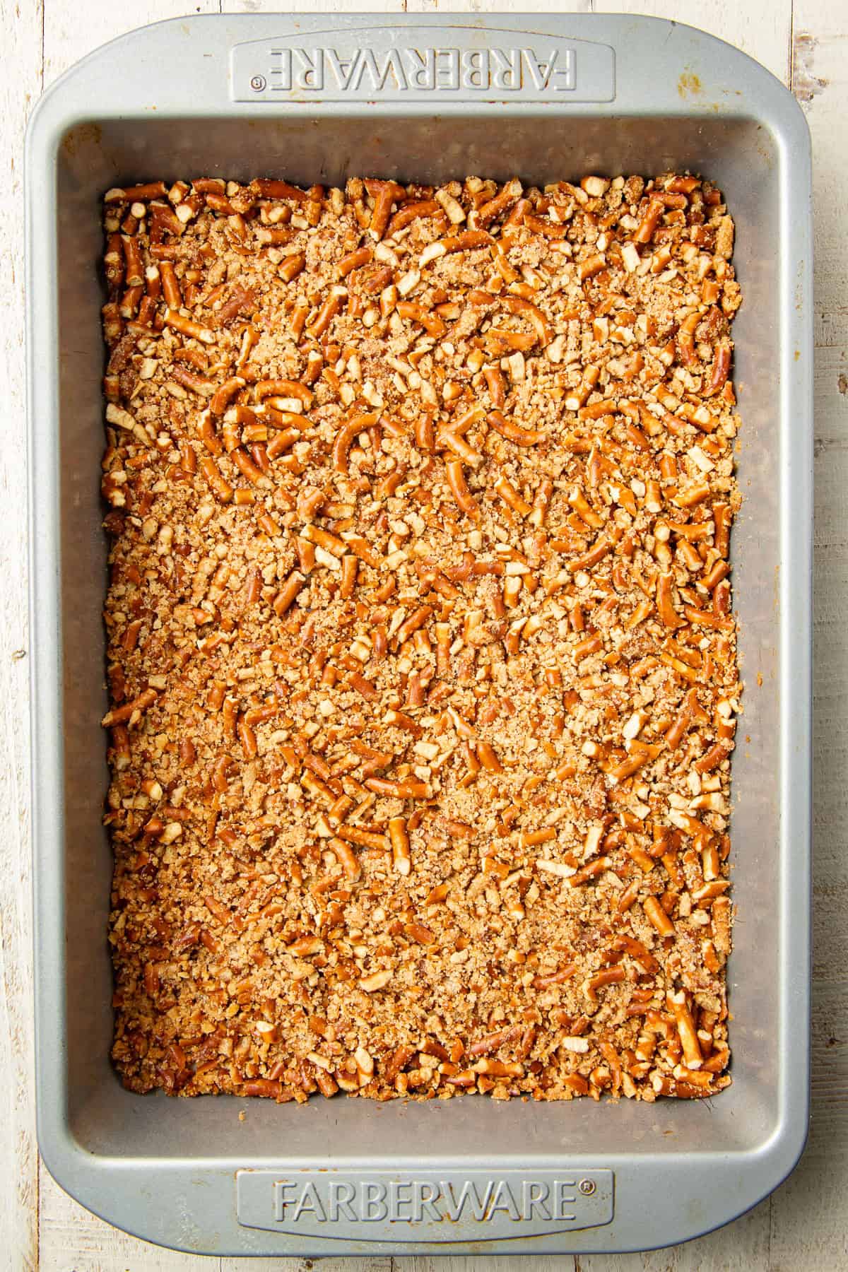 Unbaked pretzel crust in a baking pan.