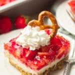 Slice of Vegan Strawberry Pretzel Salad on a plate with baking dish in the background.