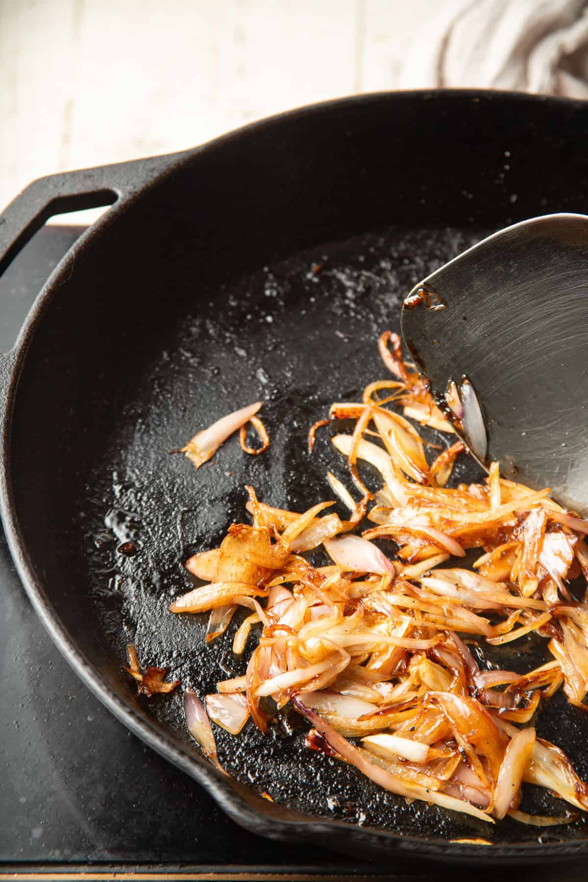 Sliced shallots cooking in a skillet.