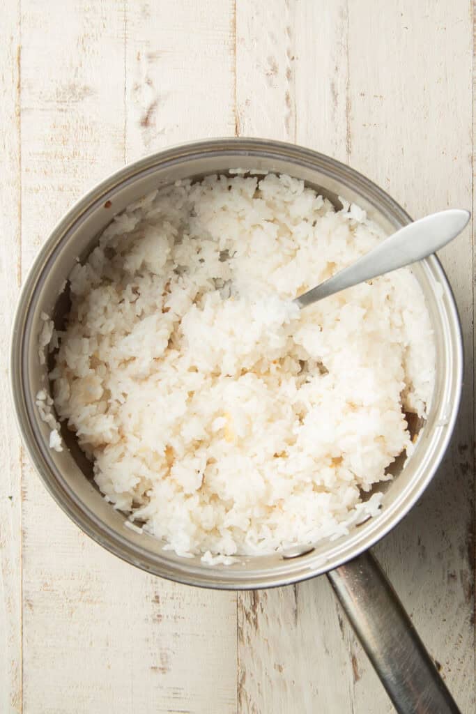 Sushi rice in a pot with fork.