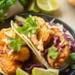 Vegan Beer-Battered Fish Tacos on a plate with lime slices.