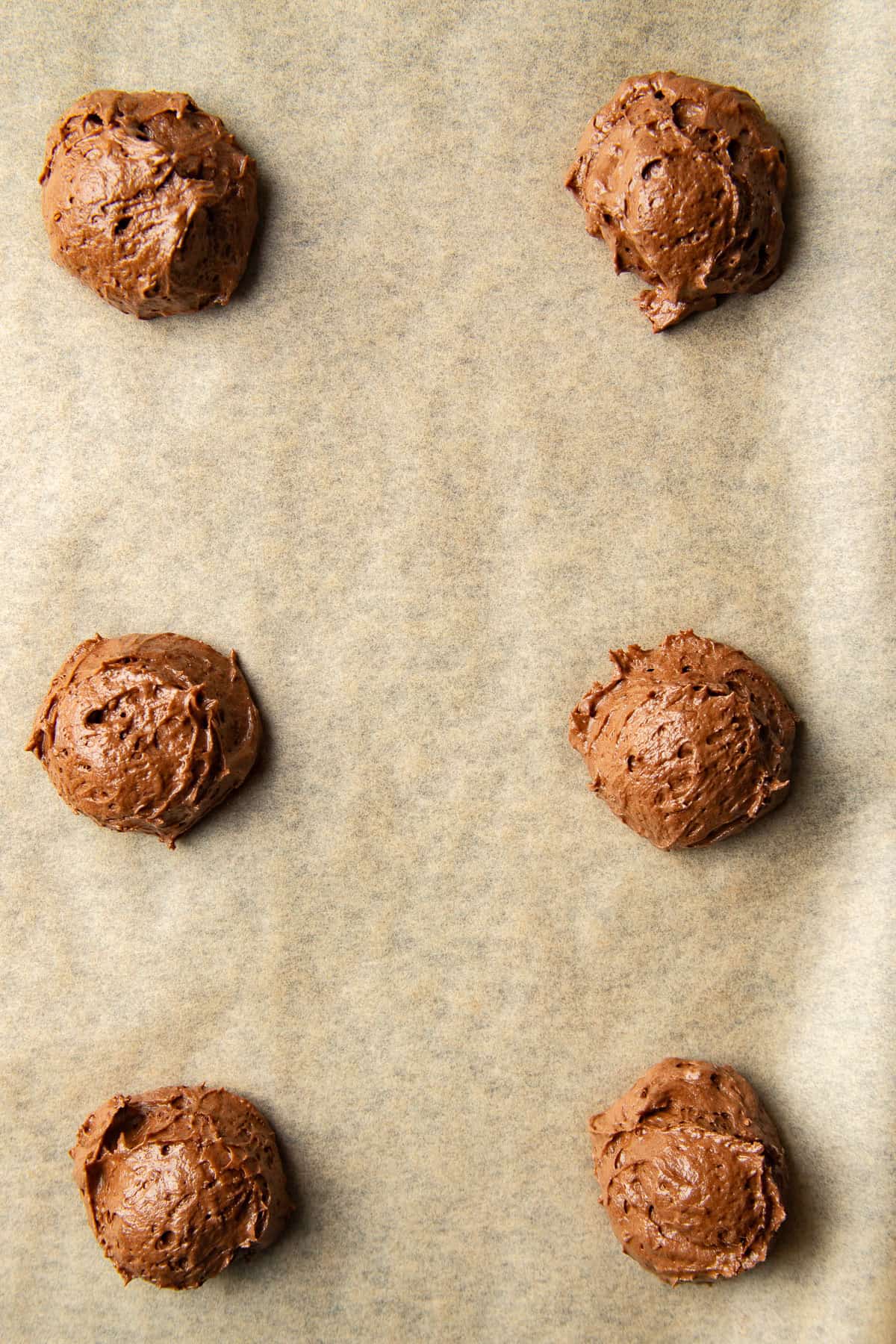 Vegan Whoopie Pie batter balls on a parchment lined baking sheet.