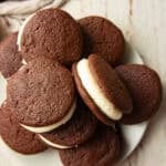Plate of Vegan Whoopie Pies on a white wooden surface.