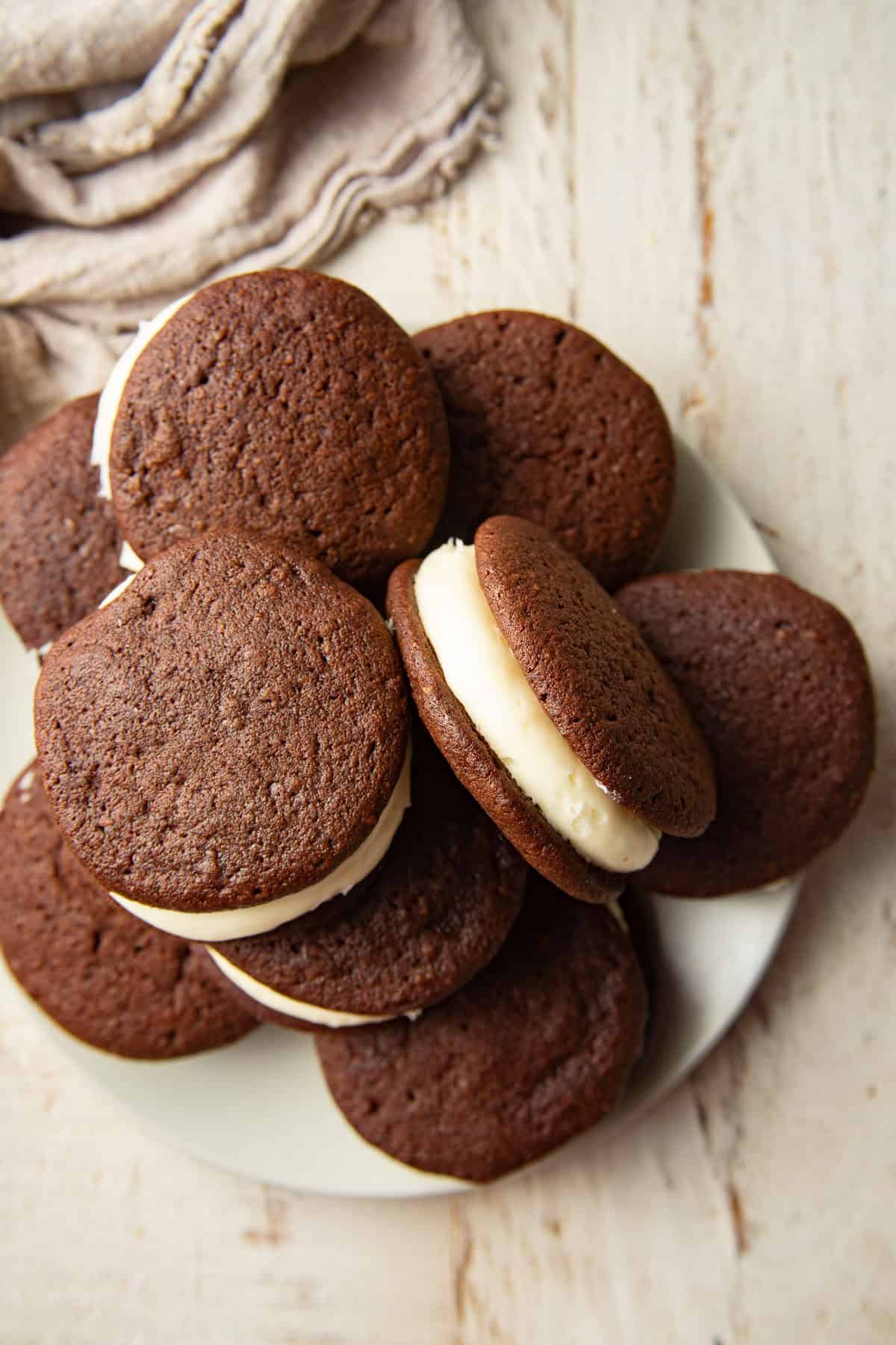 Plate of Vegan Whoopie Pies on a white wooden surface.