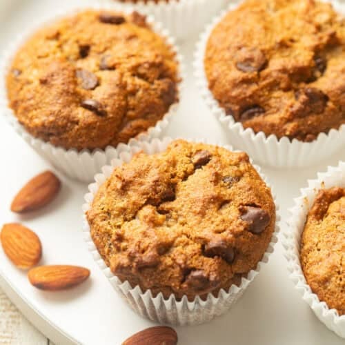 Almond Flour Banana Muffins on a plate with a few almonds.