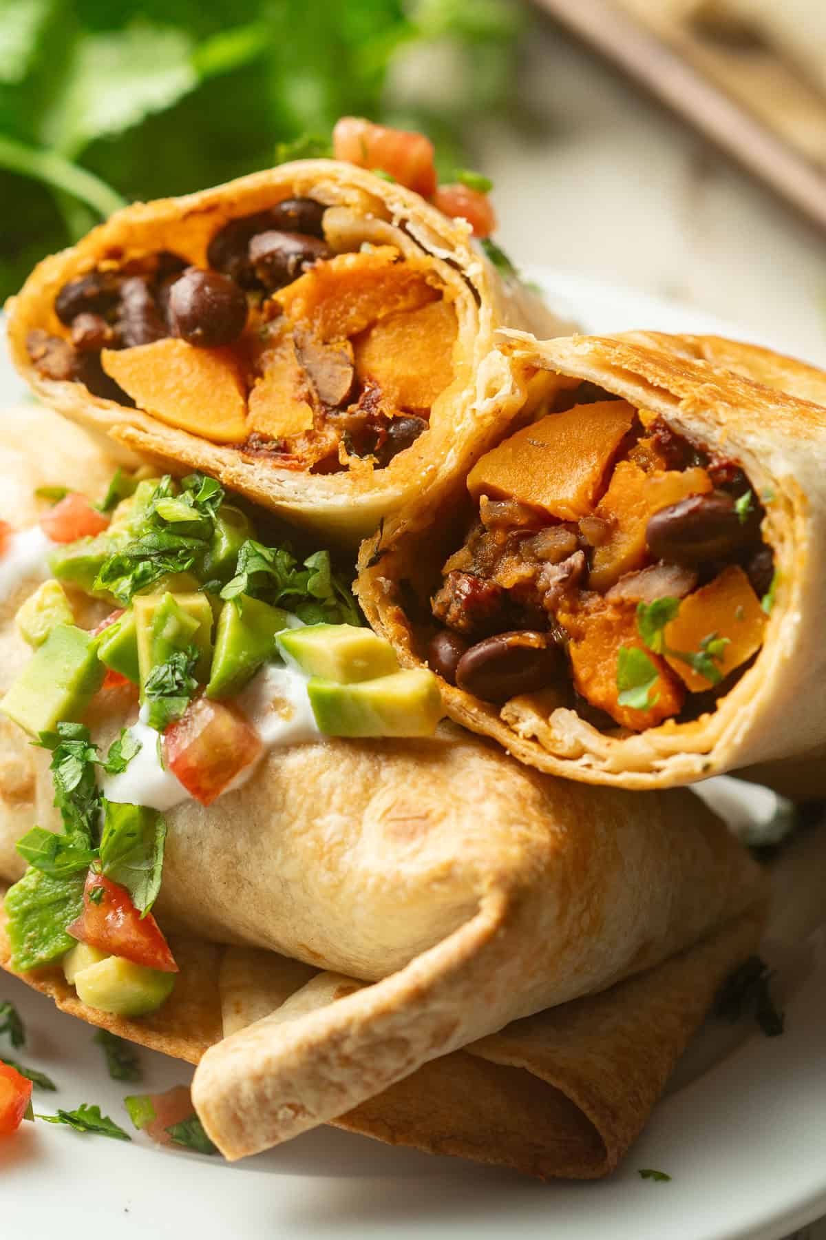 Butternut Squash Black Bean Chimichangas stacked on a plate.