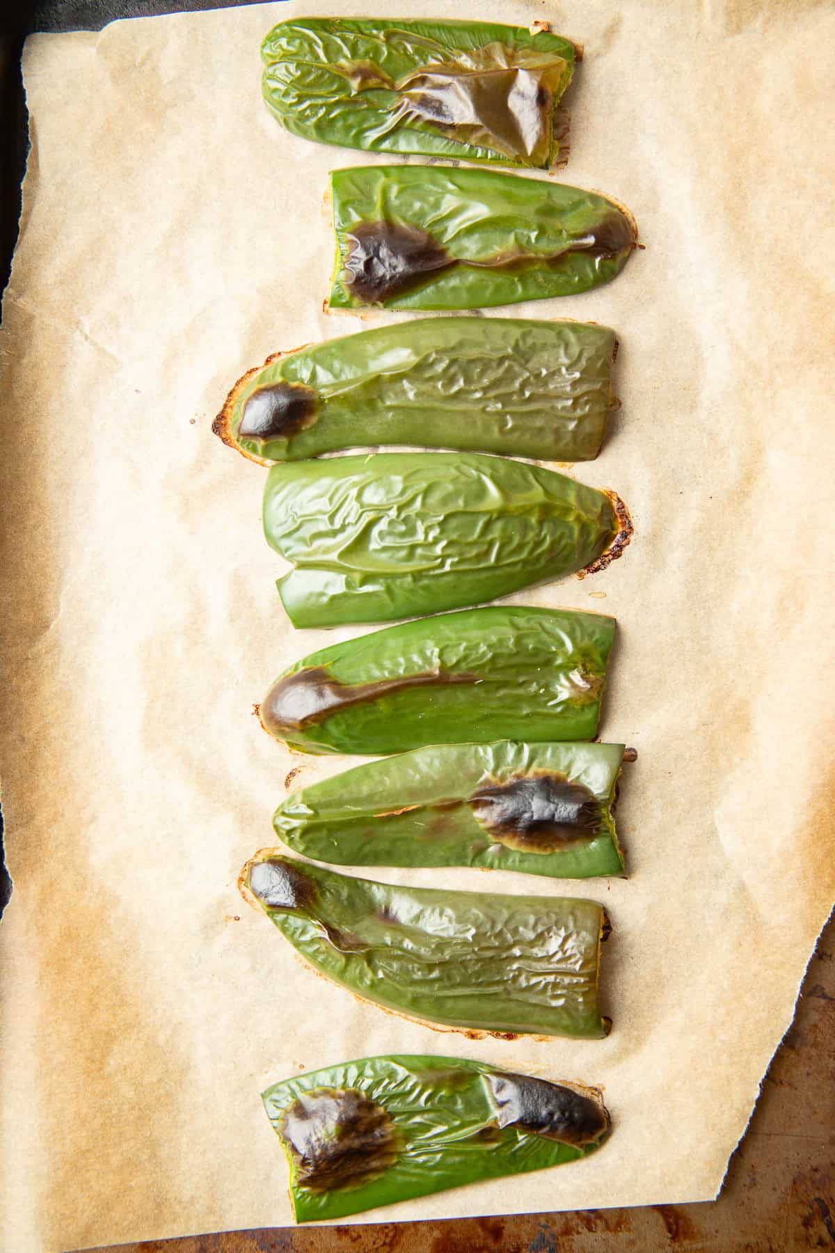 Roasted Jalapeño peppers on a baking sheet.