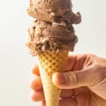 Hand holding a cone of Vegan Rocky Road Ice Cream.