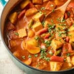Pot of Vegetable Vindaloo with wooden spoon.