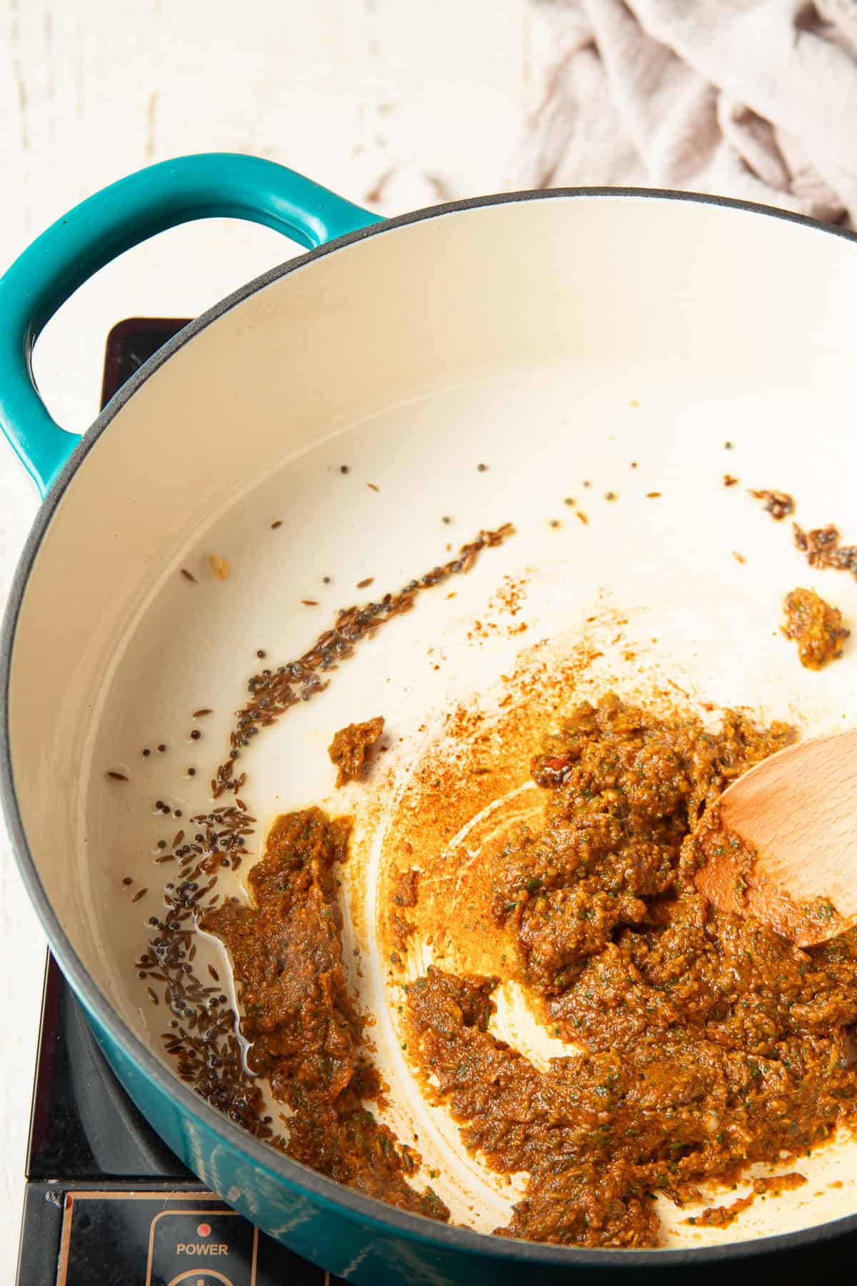 Vindaloo paste and whole spices cooking in a pot.