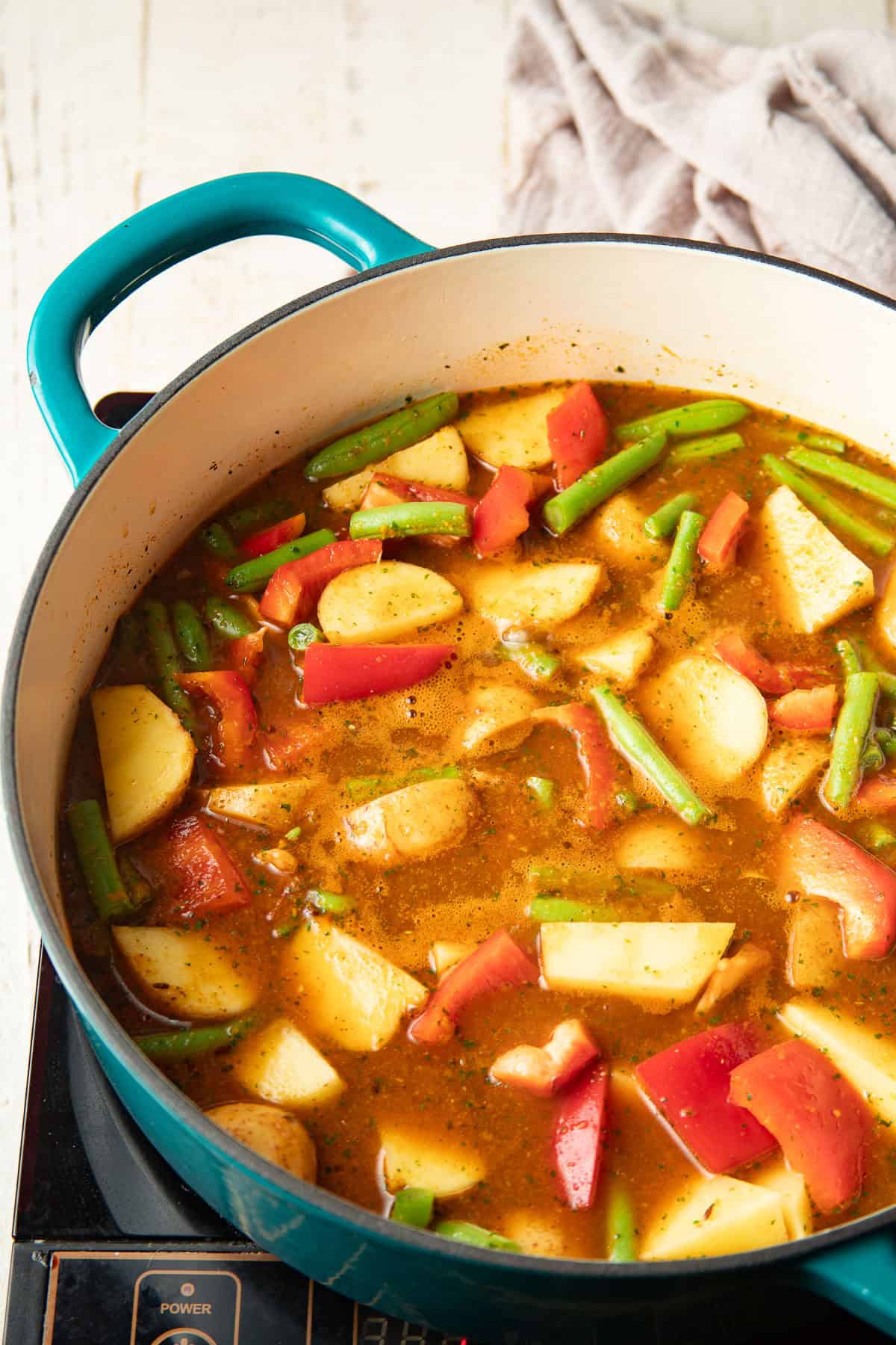 Vegetables cooking in spicy sauce in a pot.