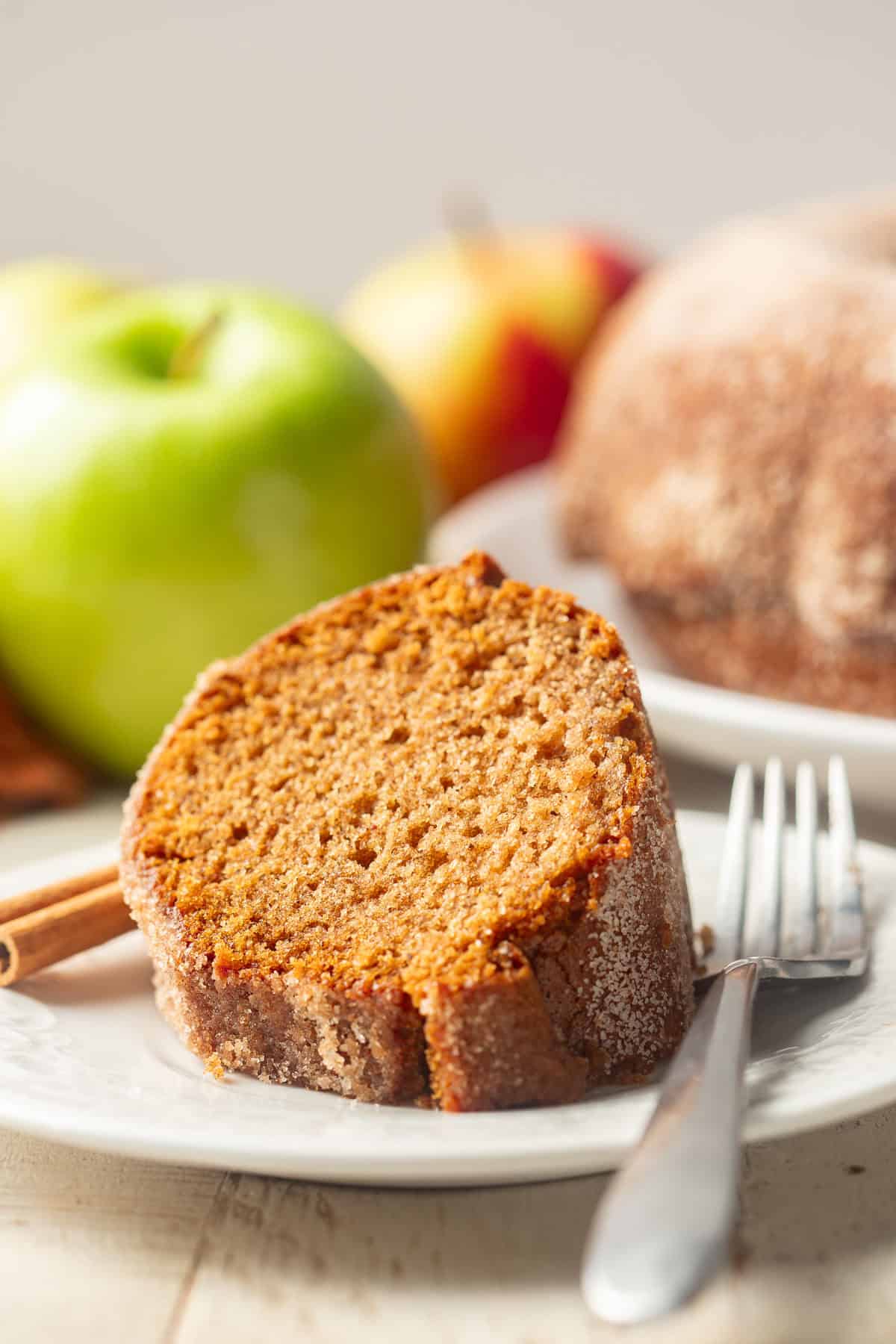 Slice of Apple Cider Doughnut Cake on a plate with fork.