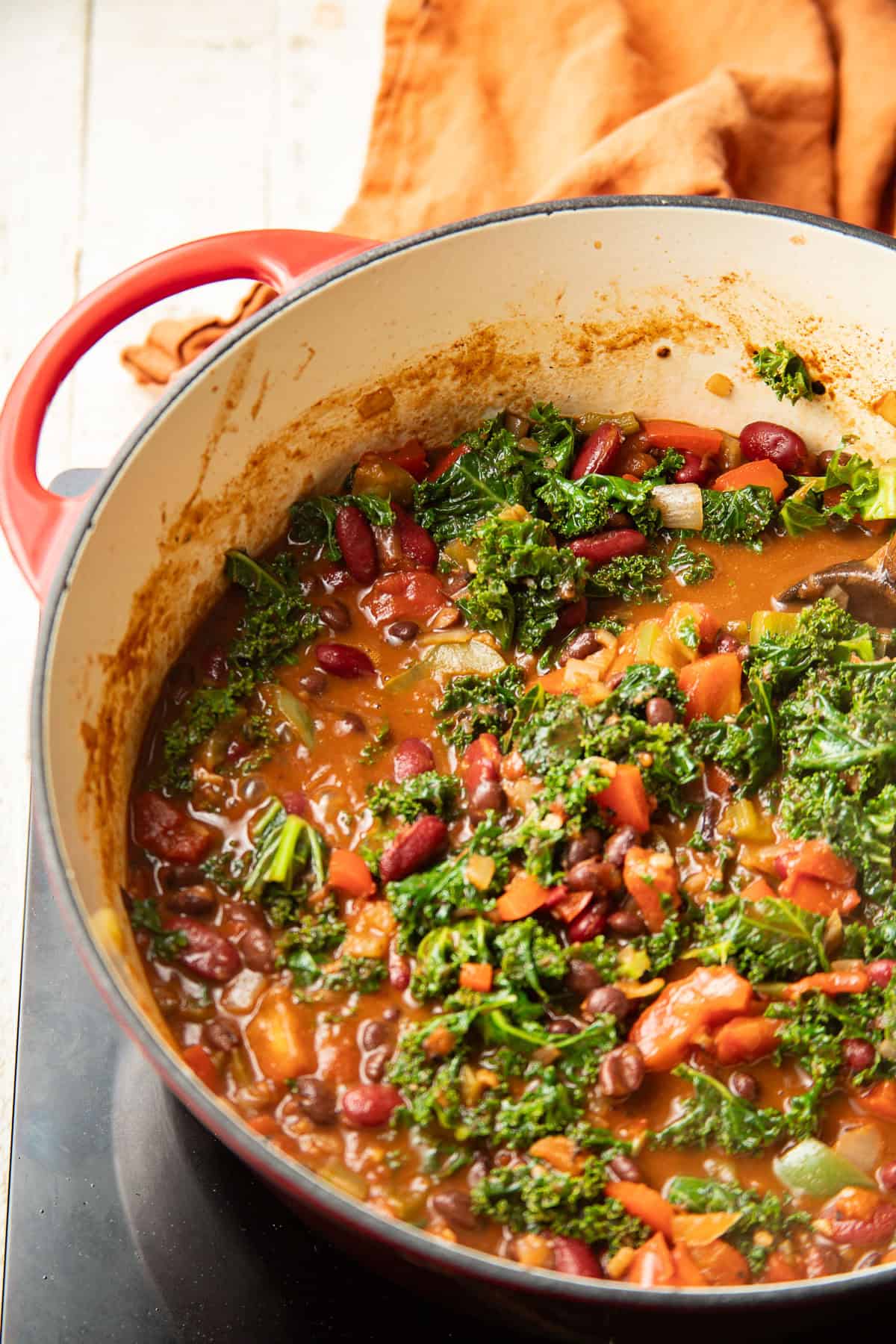 Partially cooked kale in a pot of chili.