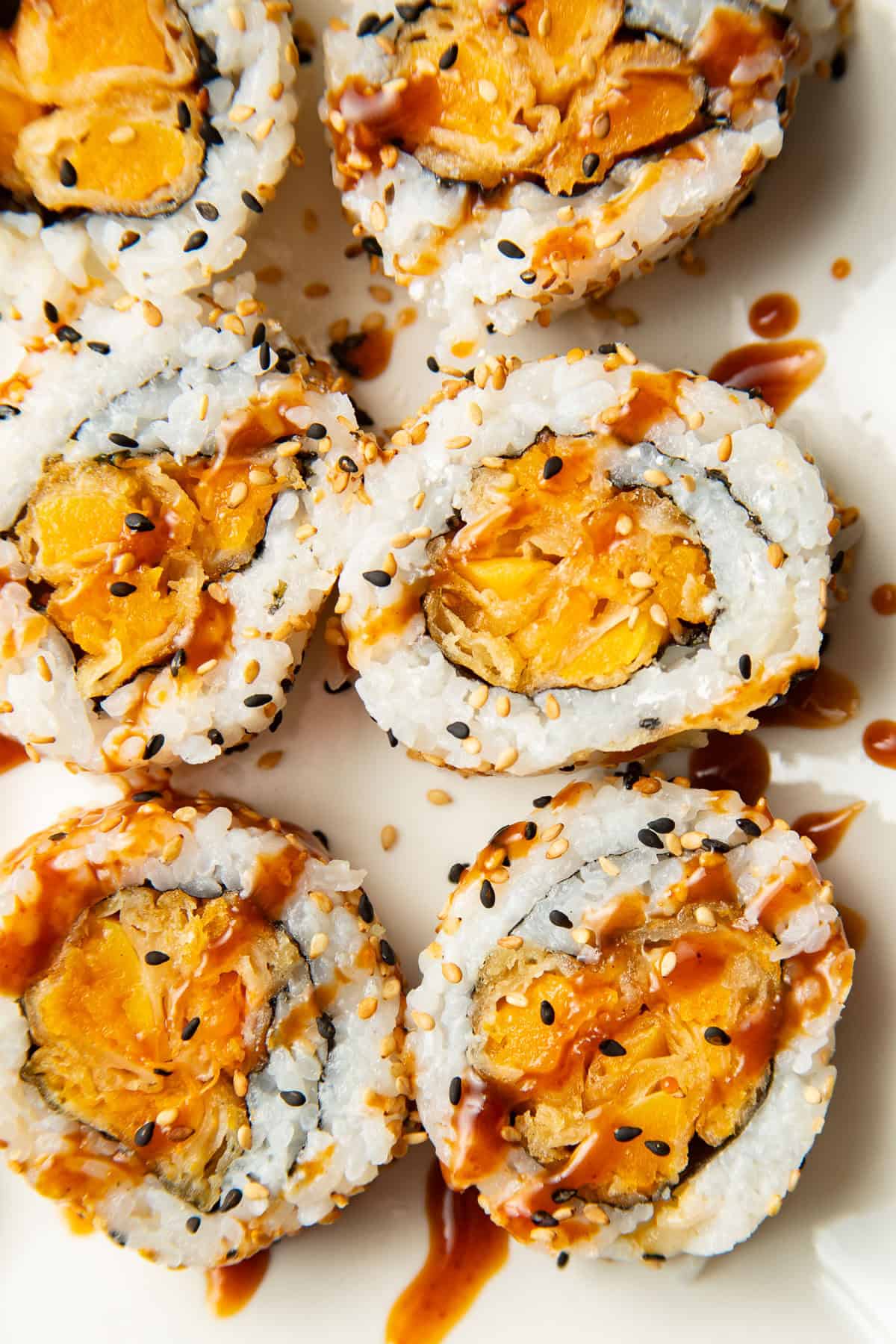 Slices of a Pumpkin Sushi roll with vegan eel sauce.