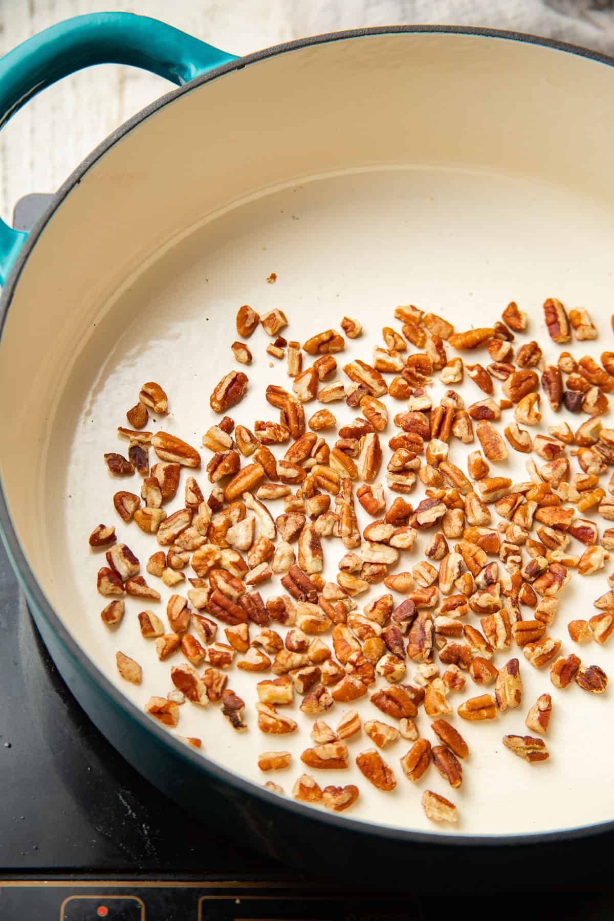 Chopped pecans toasting in a pot.