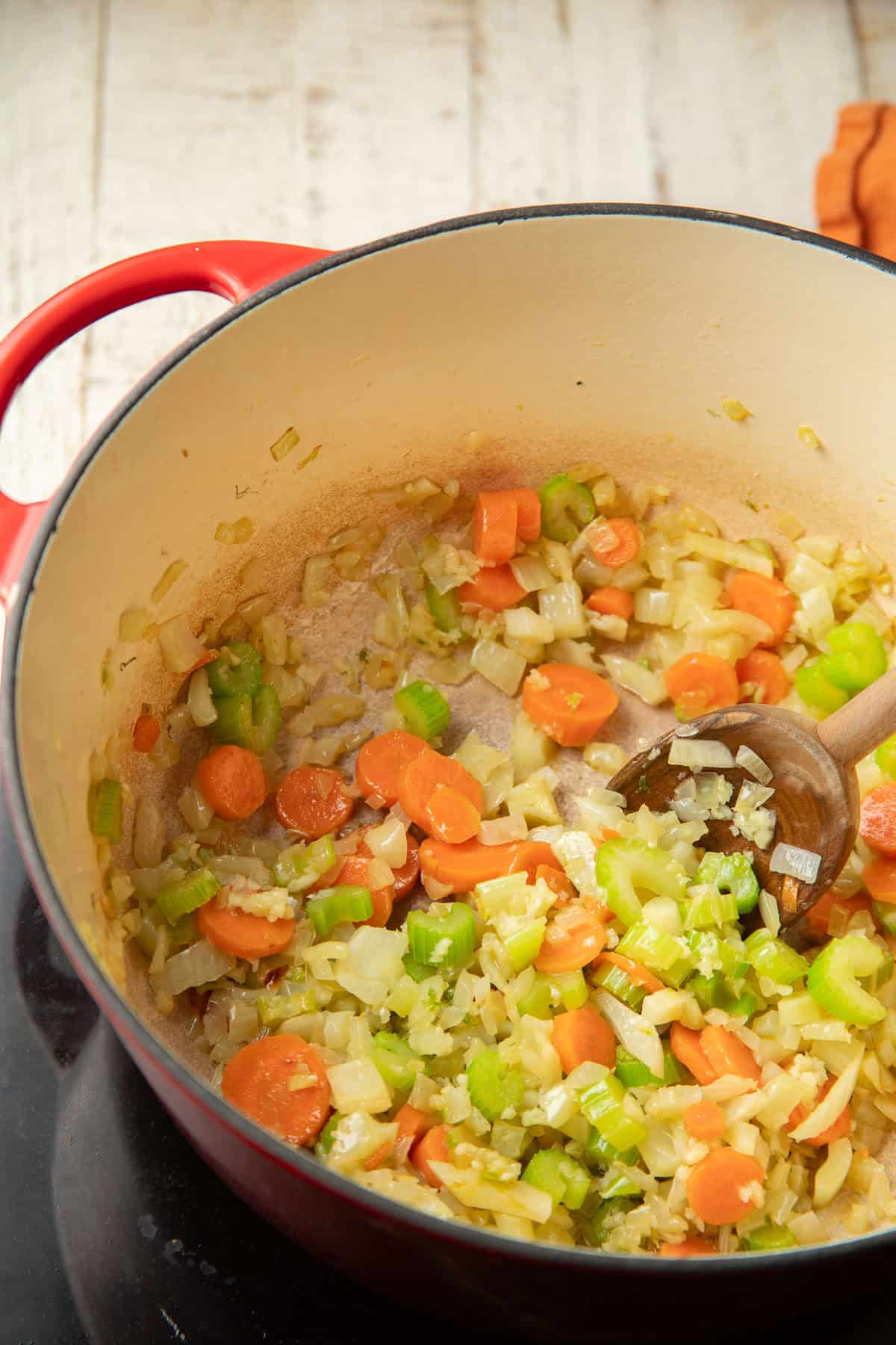 Carrots, celery, fennel, and onion cooking in a pot.