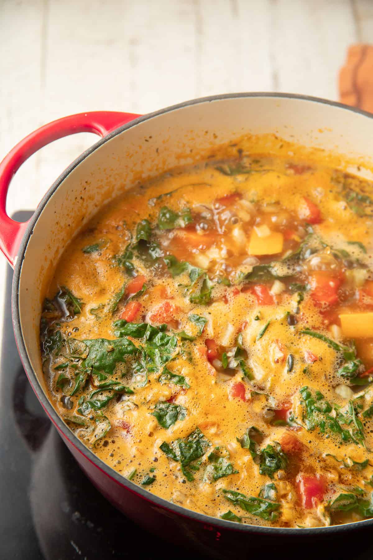 Spinach, beans, and sweet potatoes simmering in tomato broth.
