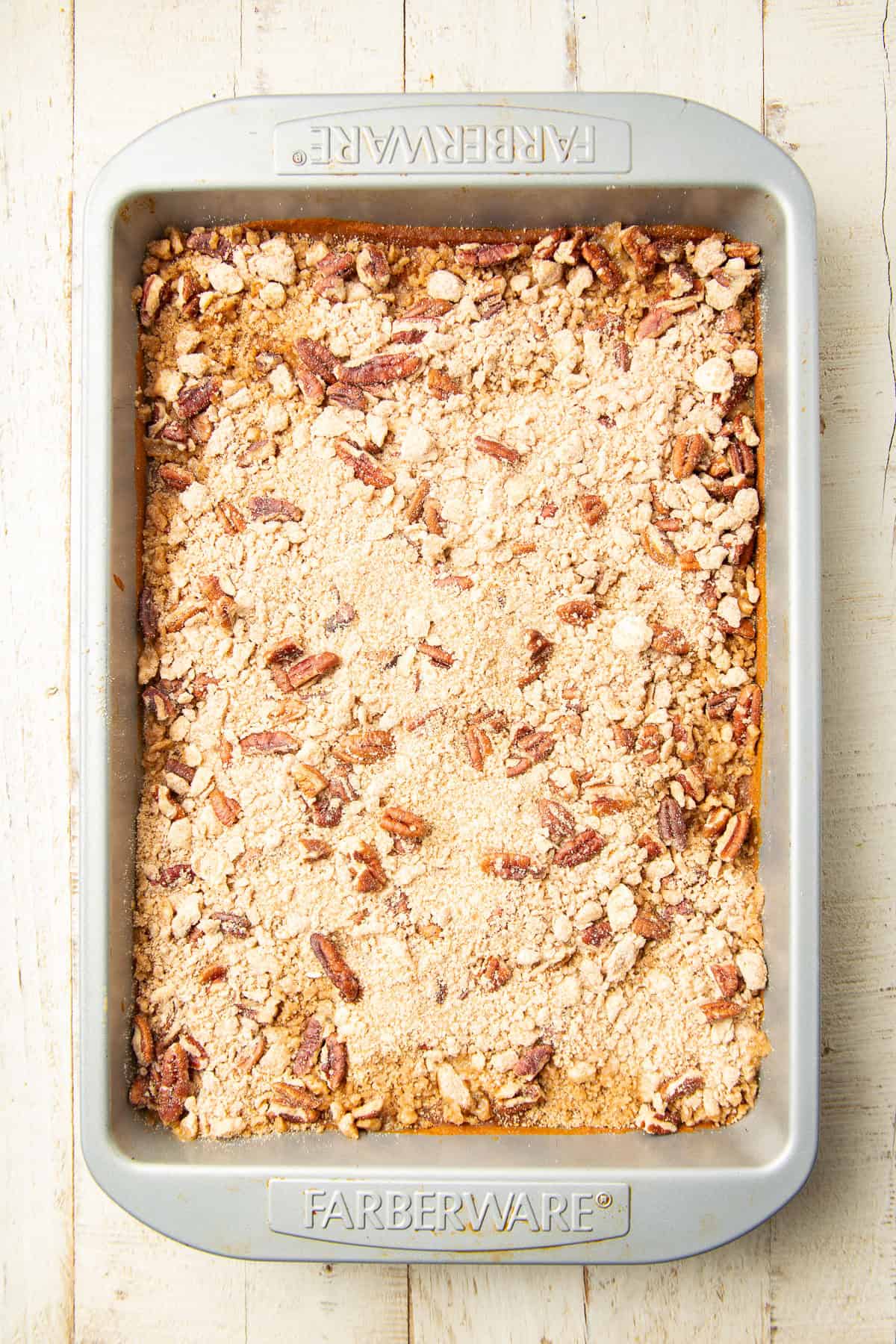 Unbaked Pumpkin Pie Bars with crumb topping in a baking pan.
