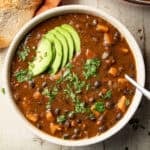 Bowl of Sweet Potato Black Bean Soup topped with sliced avocado and cilantro.